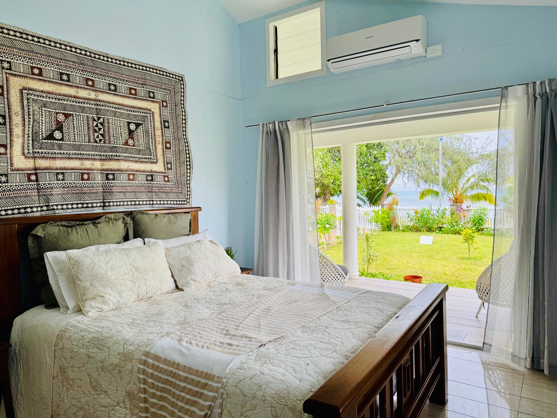 Bedroom 1: queen bed, tapa cloth, ocean view